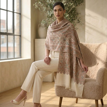 Woman sitting on a chair wearing a patterned shawl in a sunlit room.