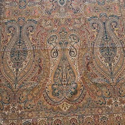 Decorative kalamkari shawl with intricate patterns on a light wooden floor.