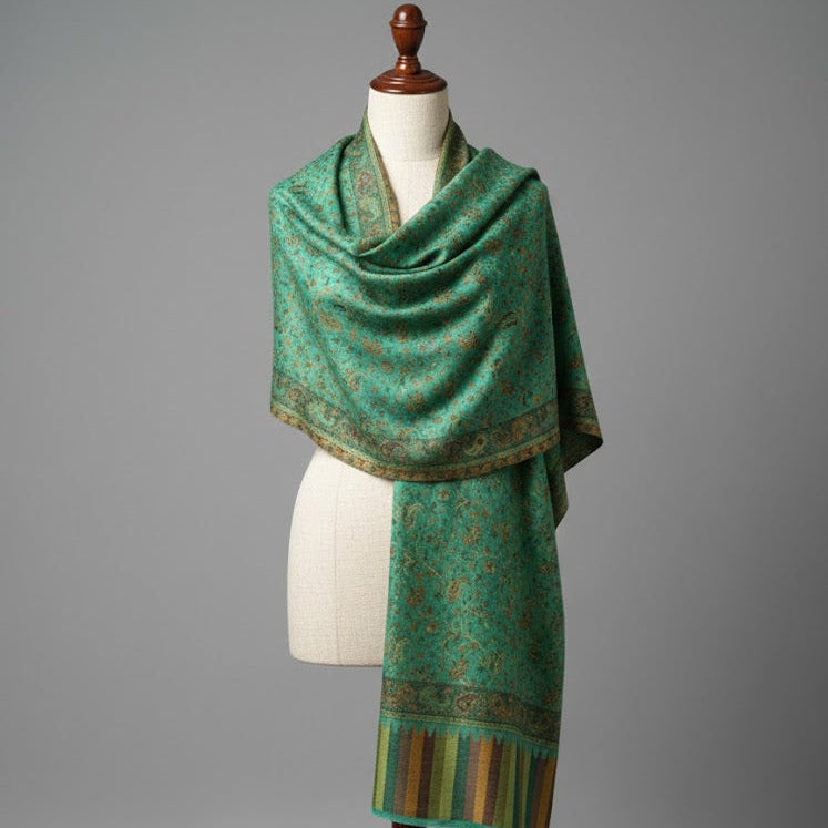 Green patterned scarf on a mannequin against a gray background