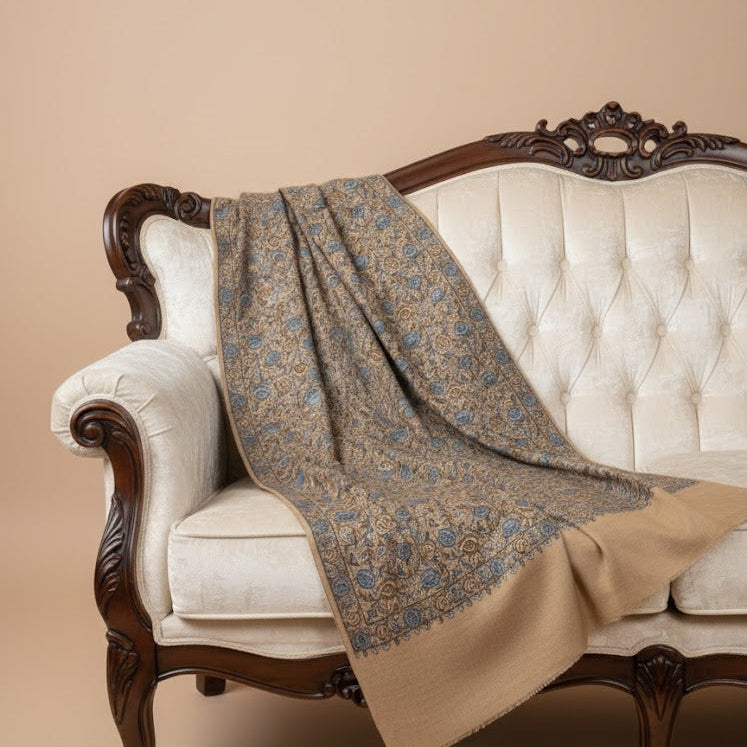 Patterned blanket draped over a decorative chair with a beige background