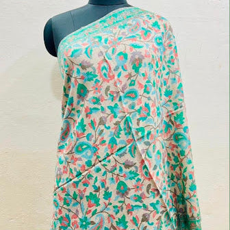 A multicolor floral printed shawl draped over a black mannequin torso, featuring a cream base with green, teal, and pink floral motifs.