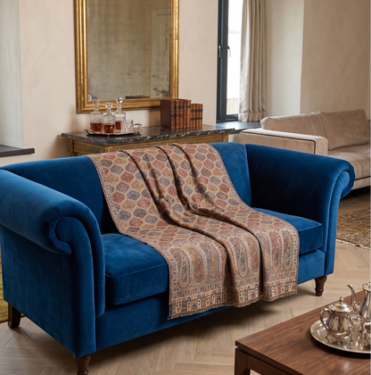 Blue sofa with a patterned throw in a stylish living room.