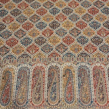 Decorative shawl with intricate patterns on a light-colored floor.