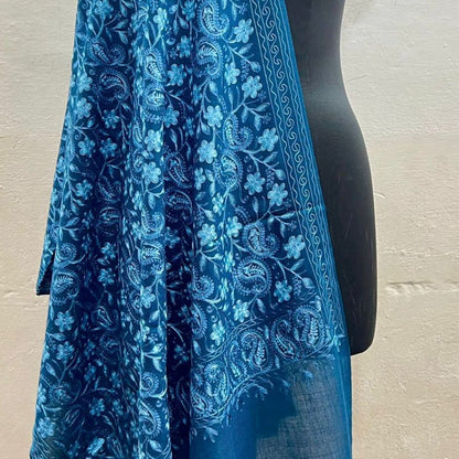 Blue floral patterned scarf draped over a mannequin against a neutral background