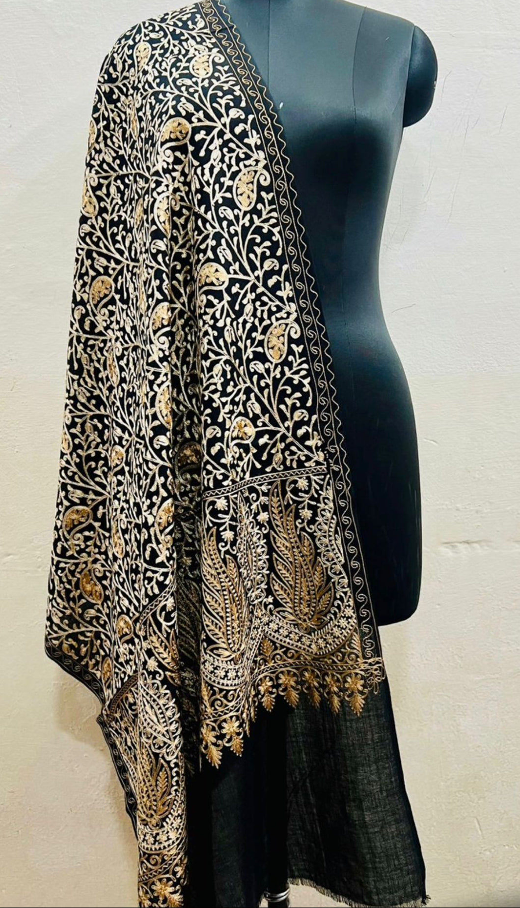 Black embroidered shawl on a mannequin against a white background