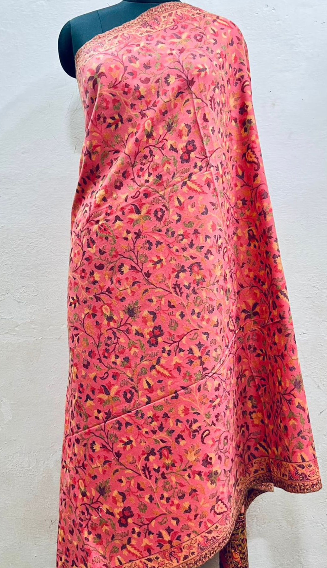 Mannequin wearing a pink floral shawl against a white background