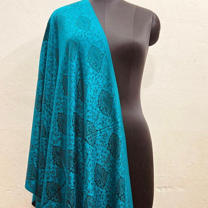 Blue patterned faux Pashmina stole draped over a mannequin against a beige background