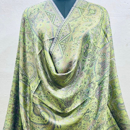 Sage green paisley patterned faux pashmina silk blend  on a mannequin against a white background