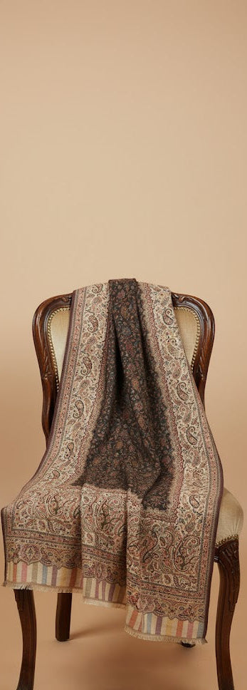 Decorative shawl draped over a chair against a beige background