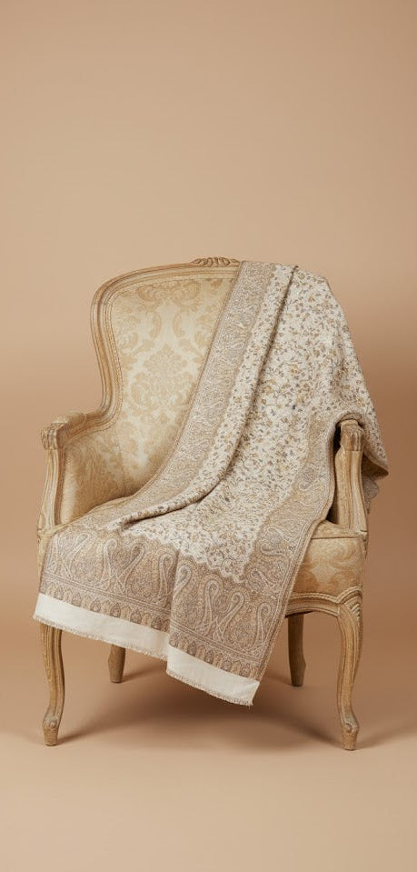 Decorative shawl draped over an ornate chair against a beige background