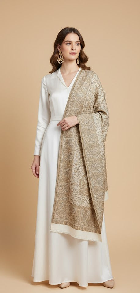 Woman wearing a long beige shawl over a white dress on a beige background