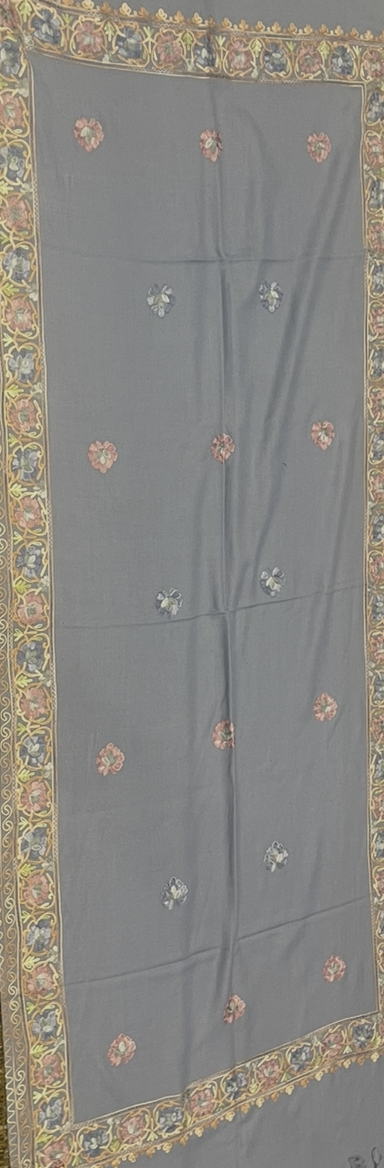 Gray fabric with intricate gold and multicolor embroidery shawl on a plain background