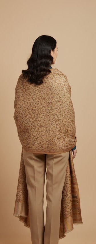 Woman wearing a patterned shawl over a plain background