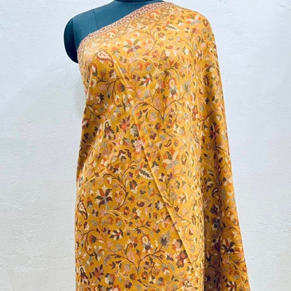 Yellow floral saree on a mannequin against a white background