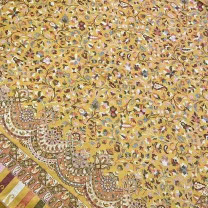 Close-up of a patterned fabric with intricate designs on a yellow background