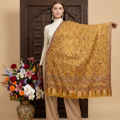 Woman holding a gold patterned scarf with flowers and a vase in the background