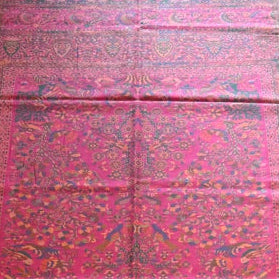 Red and pink patterned fabric on a wooden floor