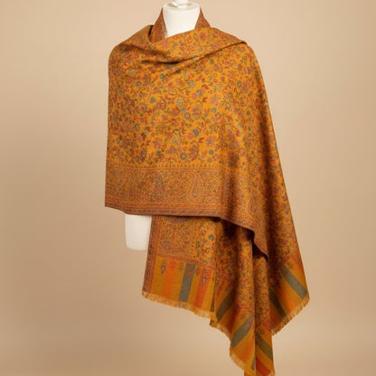 Orange patterned scarf on a mannequin against a beige background