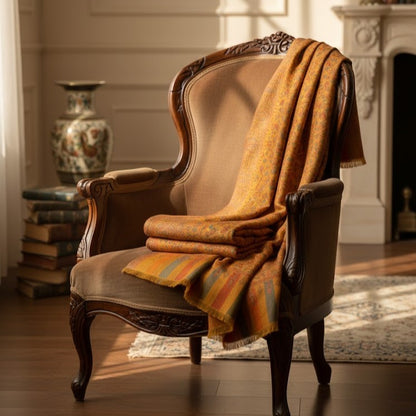 Decorative armchair with a patterned blanket draped over it in a warm, sunlit room.