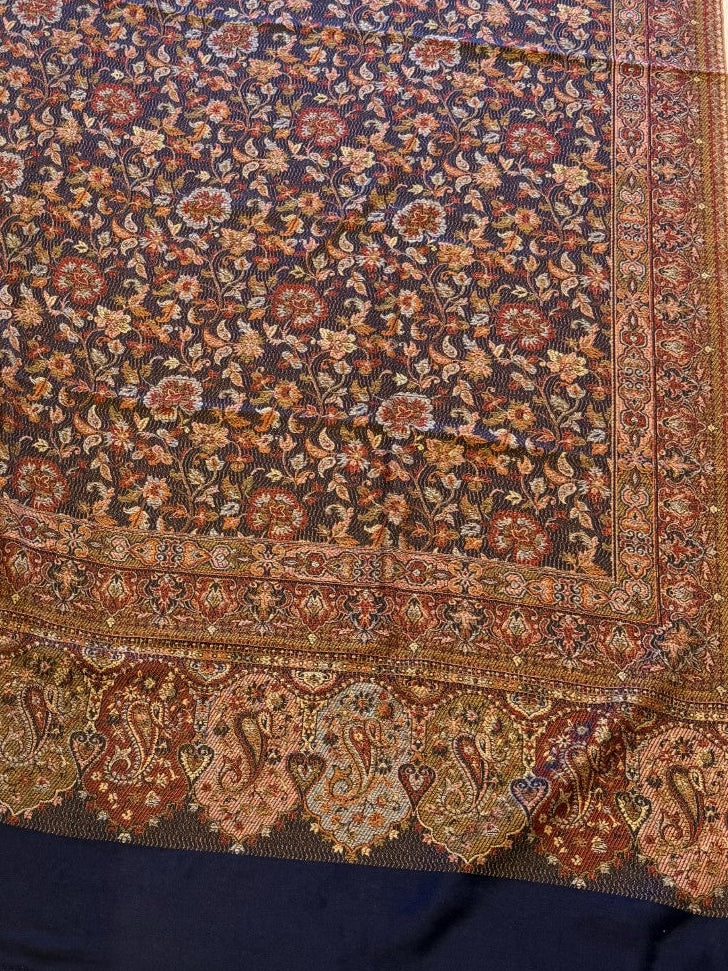 Decorative deep indigo blue hand woven pure wool patterned jamawar kani shawl with intricate patterns on a light wooden surface