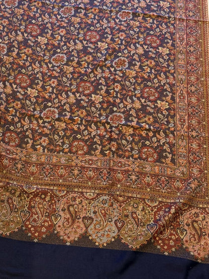 Decorative deep indigo blue hand woven pure wool patterned jamawar kani shawl with intricate patterns on a light wooden surface