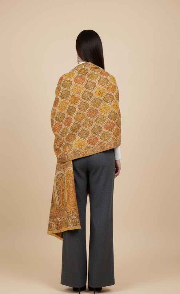 Woman wearing a patterned Yellow patterned kalamakari kani double beam stole in pure wool over a plain background
