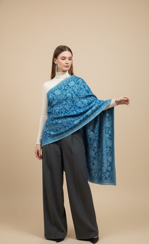 Woman wearing a blue floral patterned shawl over a beige background