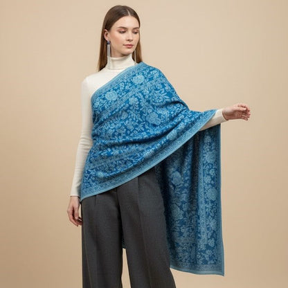 Woman wearing a blue floral patterned shawl over a beige background
