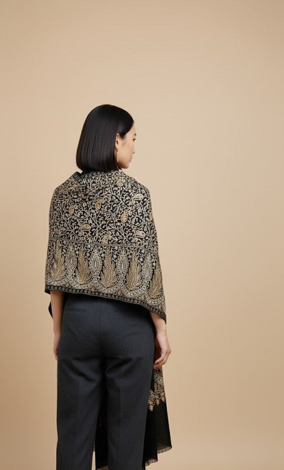 Woman wearing a patterned shawl over a plain background