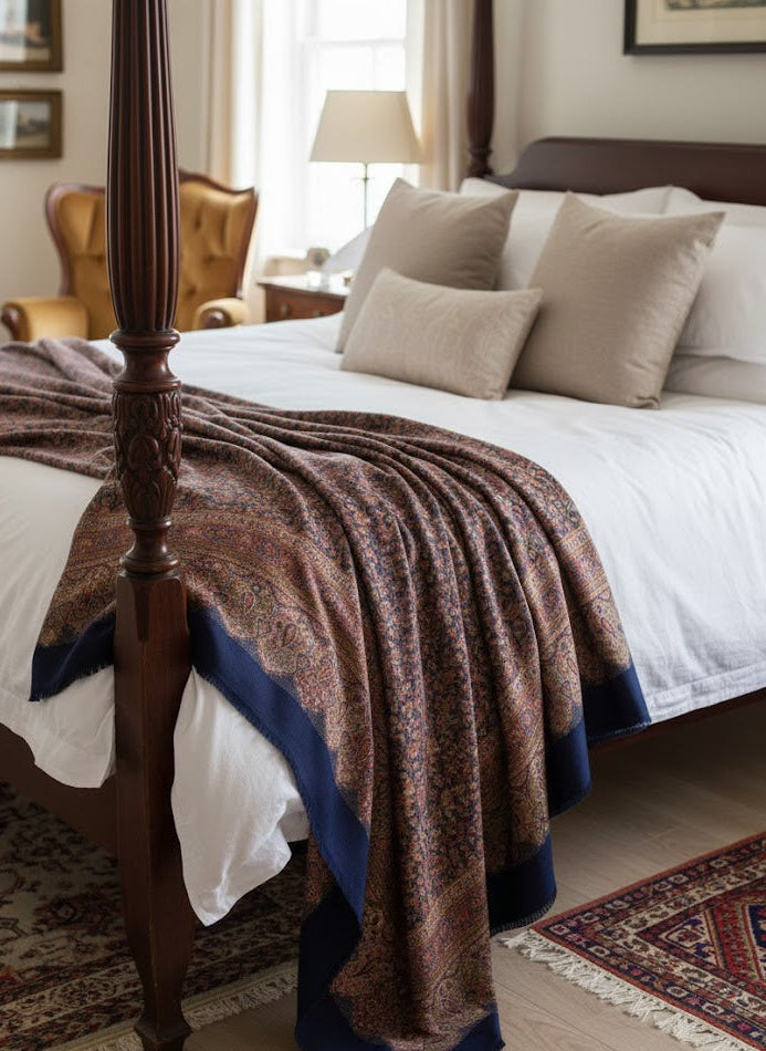 Bedroom with a four-poster bed and deep indigo blue hand woven pure wool patterned jamawar kani shawl draped over it.