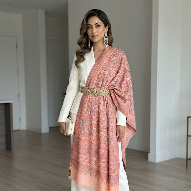 Woman wearing a white outfit with a pink patterned shawl in an indoor setting