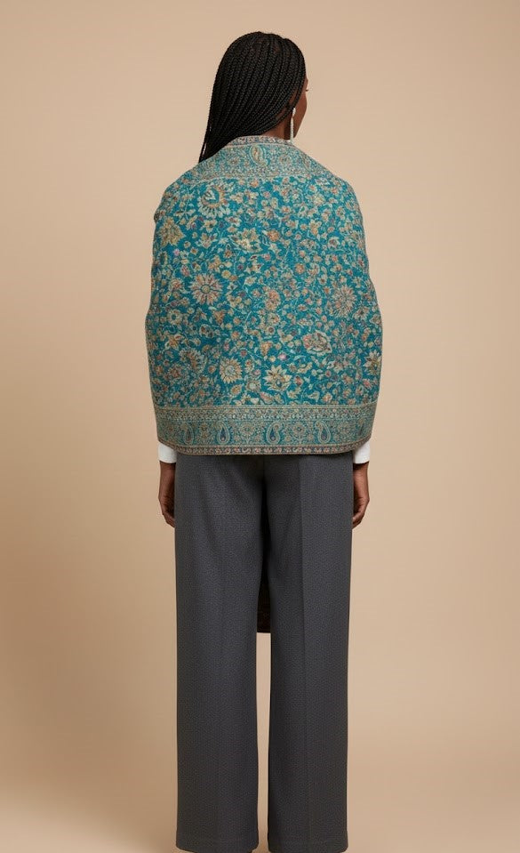 Person wearing a teal floral patterned jacket on a beige background