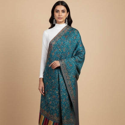 Woman wearing an azure blue faux Pashmina patterned stole over a white top on a beige background