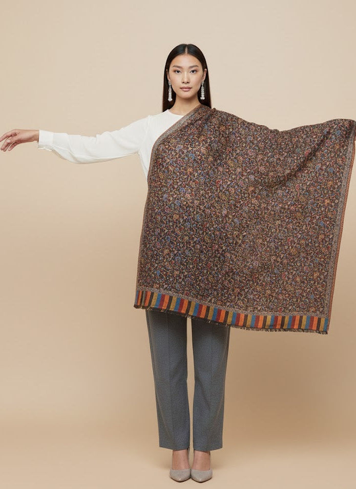 Woman wearing a patterned shawl over a plain background