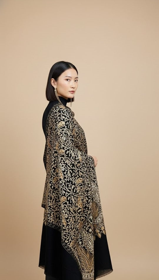 Woman wearing a hand embroidered shawl against a beige background