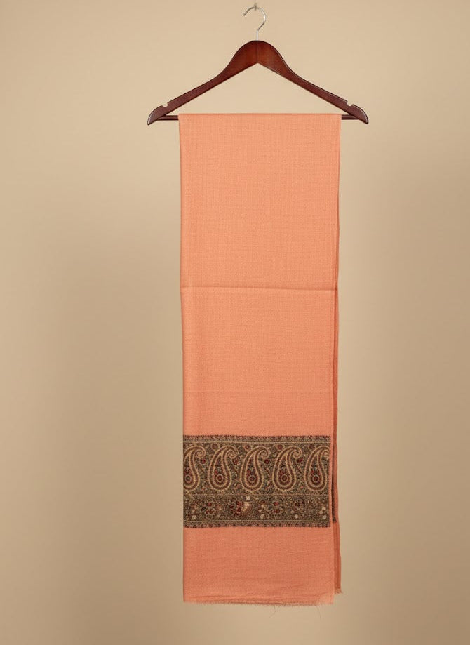 Peach pashmina shawl with a black border on a beige background