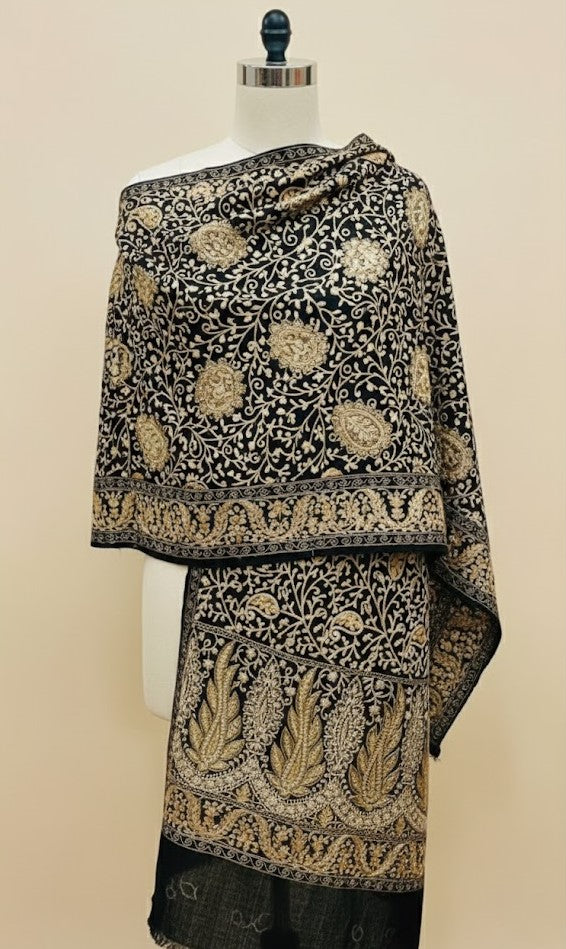Black and gold embroidered shawl on a mannequin against a beige background