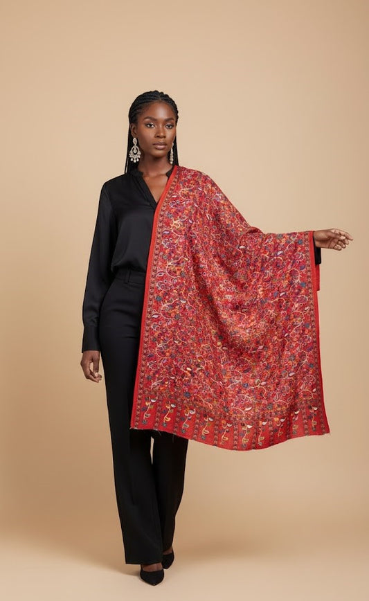 Woman wearing a black outfit with a red patterned paisley kalamkari-inspired stole in faux pashmina on a beige background