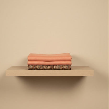 Beige shelf with folded towels on a beige wall