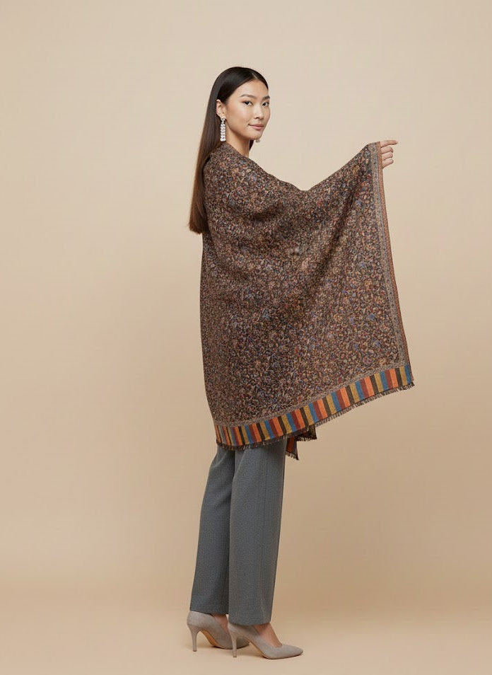 Woman wearing a patterned shawl over a plain background