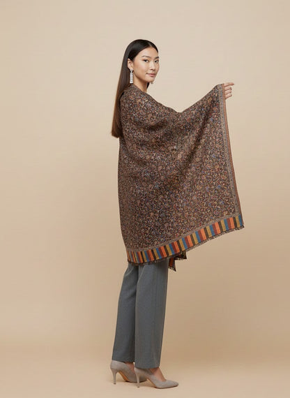 Woman wearing a patterned shawl over a plain background