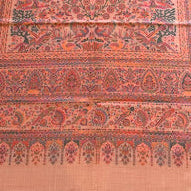 Decorative shawl with intricate patterns on a wooden floor