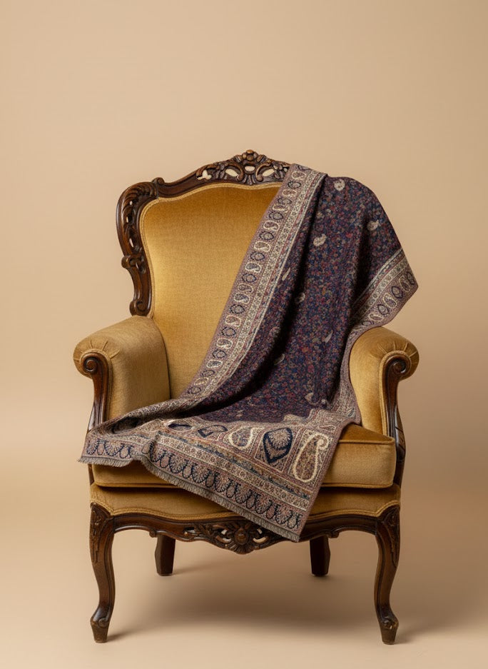 Decorative patterned kalamkari hand embroidered shawl ket draped over an ornate chair on a beige background