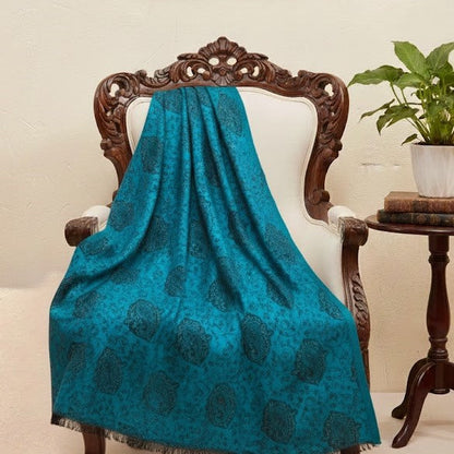 Blue faux Pashmina stole draped over a wooden chair with a neutral background
